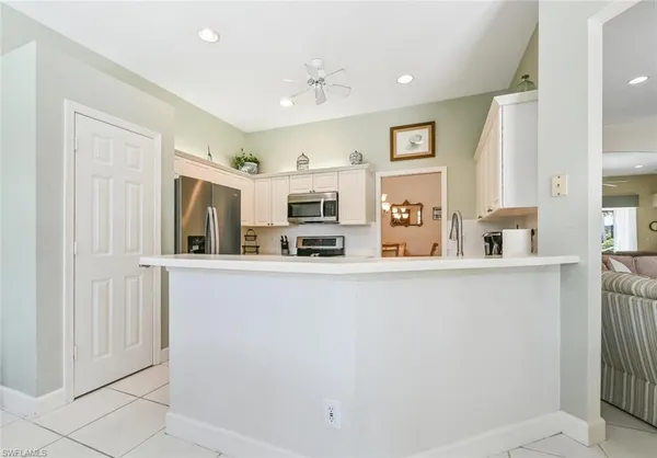 a living room with stainless steel appliances a refrigerator and a cabinets