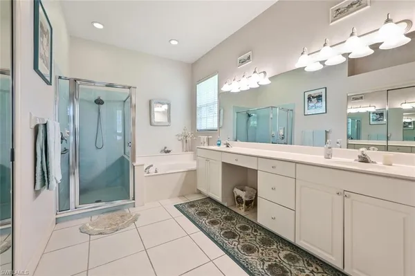 a spacious bathroom with a double vanity sink mirror and shower