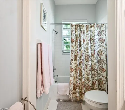 a bathroom with a toilet and a shower curtain