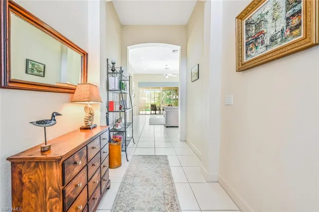 a hallway with painting on the wall and a large mirror