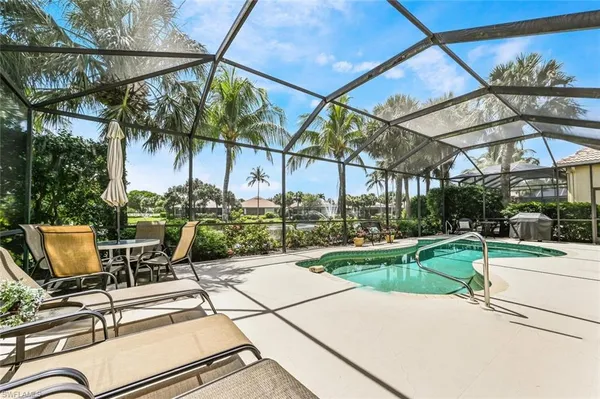 a view of a patio with a table and chairs under an umbrella