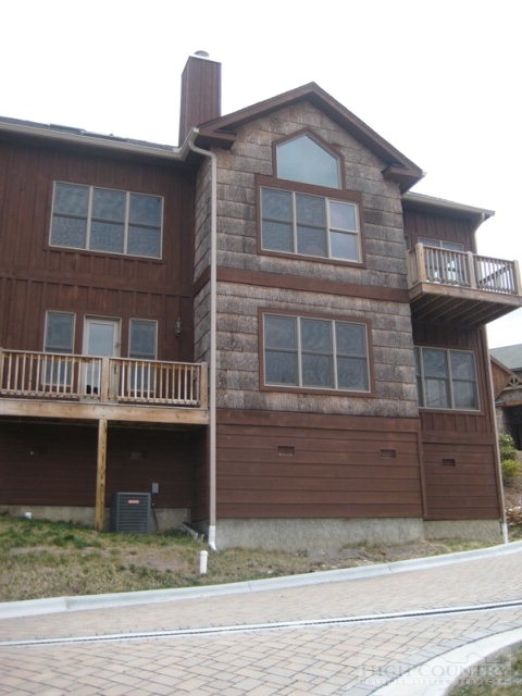 145-8 Banner Road Southwest, Unit 8 Banner Elk, NC 28604 - Photo 11 of 22 a front view of a house with glass windows and a yard