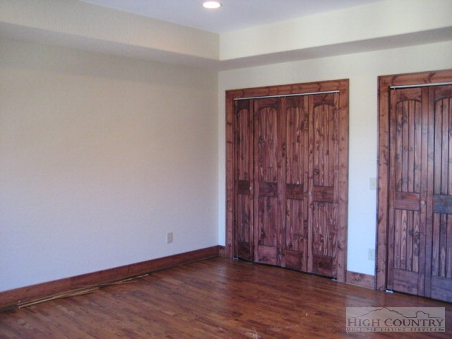 145-8 Banner Road Southwest, Unit 8 Banner Elk, NC 28604 - Photo 9 of 22 an empty room with wooden floor and windows