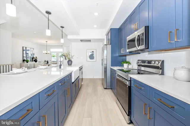 a large kitchen with stainless steel appliances granite countertop a lot of counter space and wooden cabinets