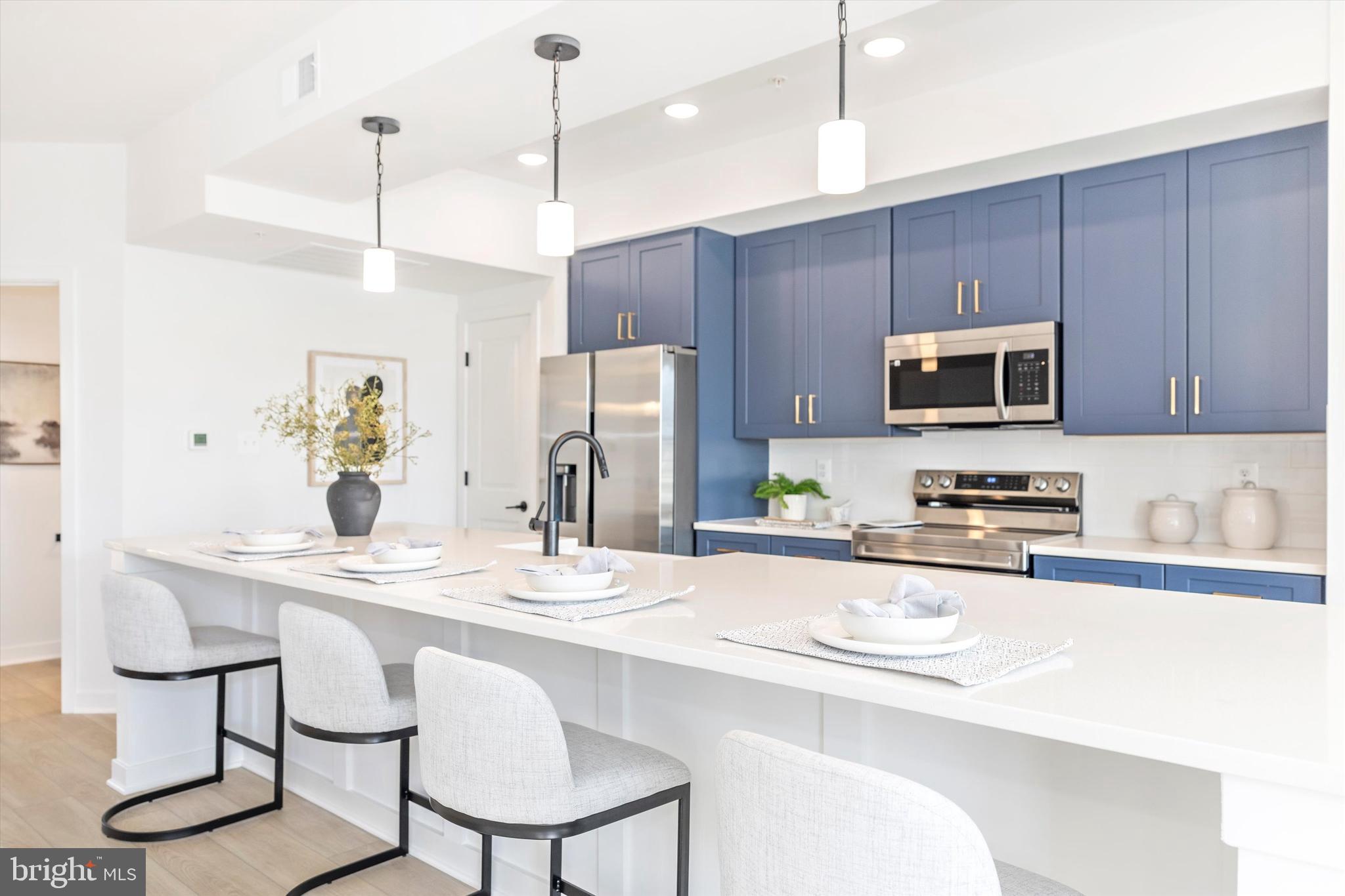 a kitchen with stainless steel appliances granite countertop a sink a microwave a refrigerator and a stove