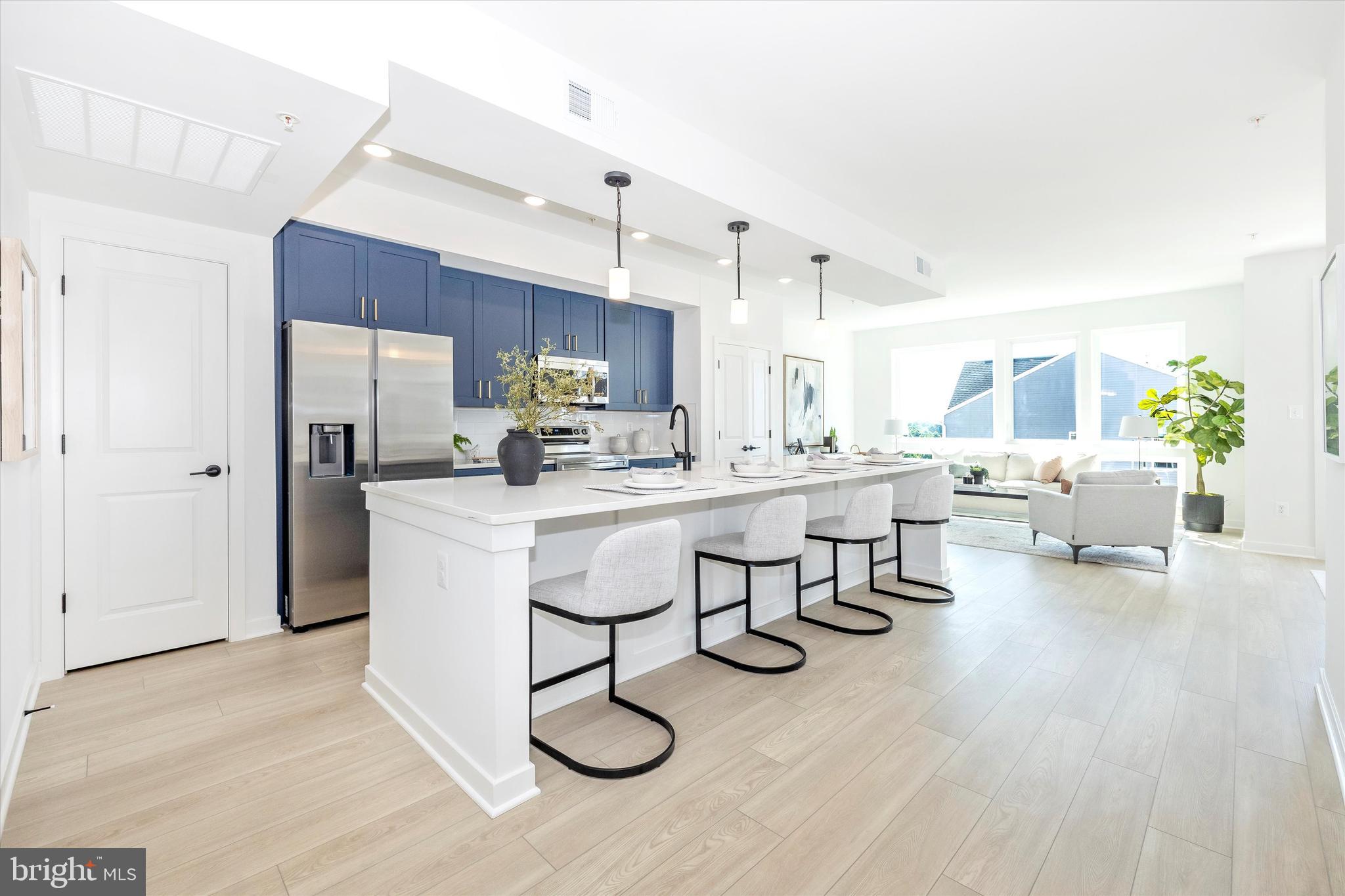 1631 A Blacksmith Way Frederick, MD 21702 - Photo 11 of 35 a living room with couches and kitchen view with wooden floor