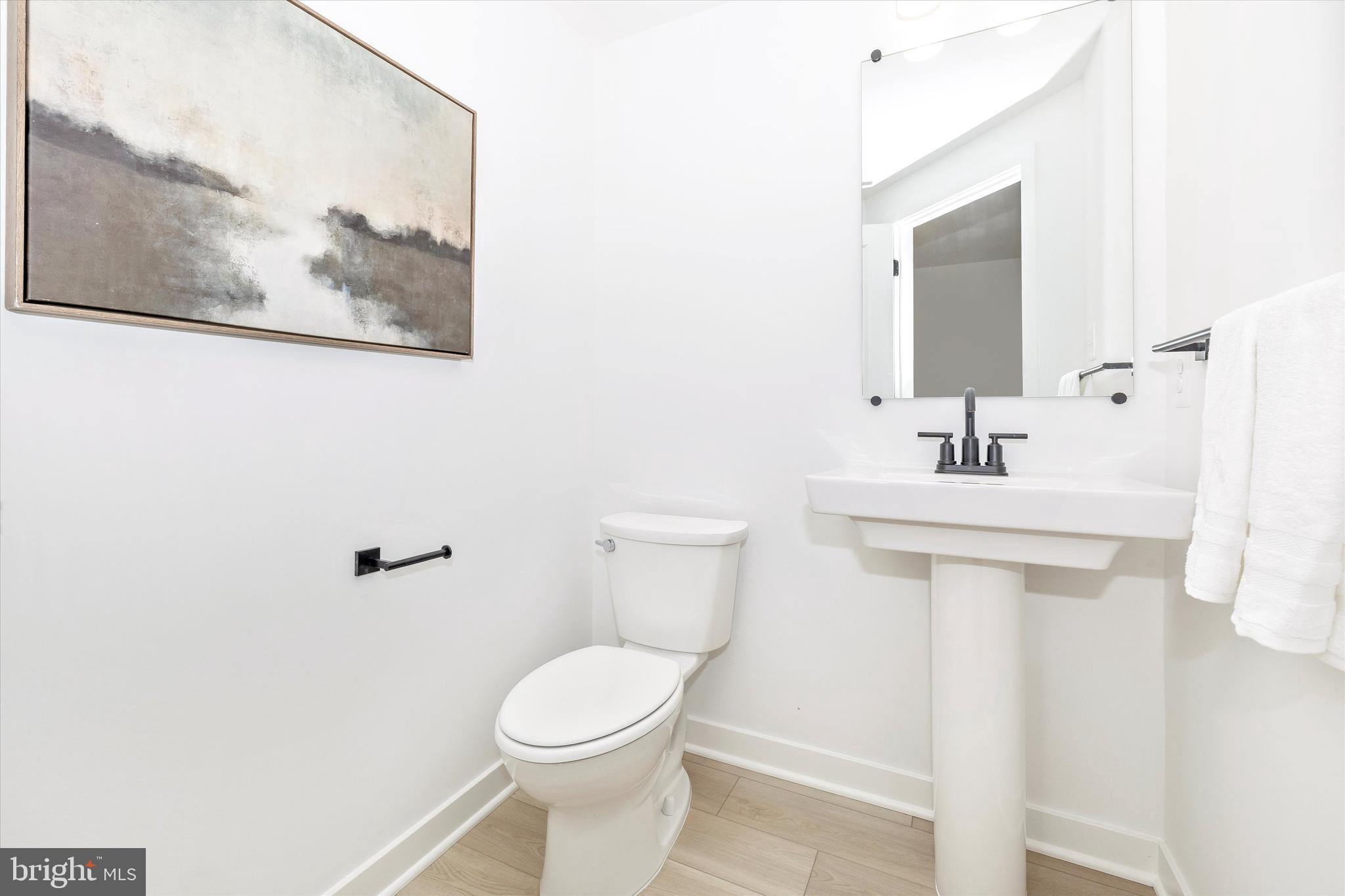 1631 A Blacksmith Way Frederick, MD 21702 - Photo 23 of 35 a bathroom with a toilet a sink and mirror
