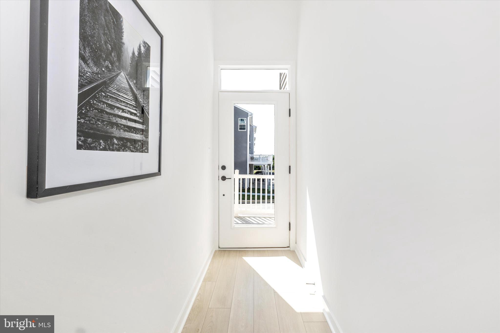 1631 A Blacksmith Way Frederick, MD 21702 - Photo 3 of 35 a view of a hallway with wooden floor and a bathroom