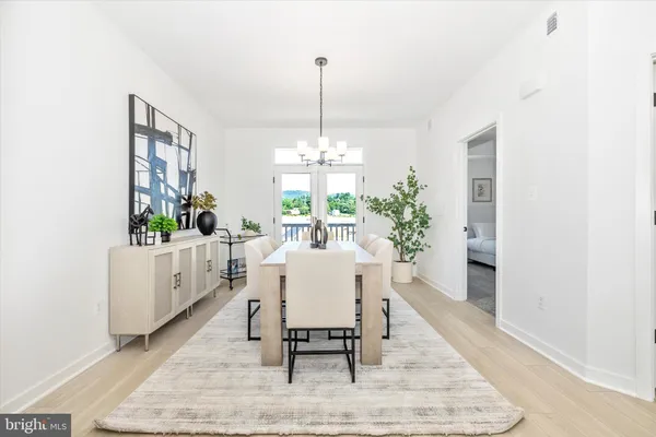 a dining room with furniture a chandelier and wooden floor