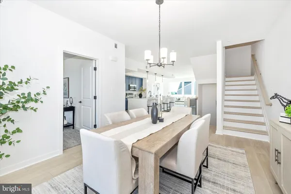 a dining room with chandelier and wooden floor