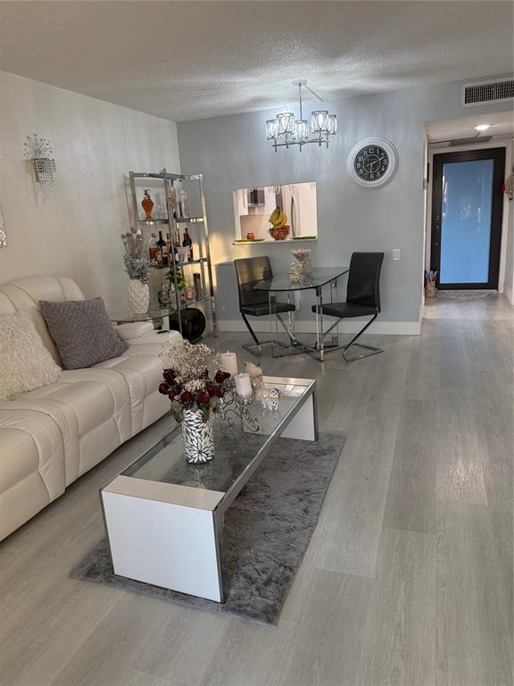 9360 Lime Bay Boulevard, Unit 202 Tamarac, FL 33321 - Photo 12 of 15 a living room with couches and a large mirror with wooden floor