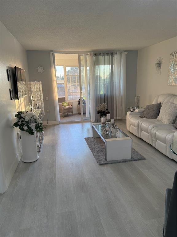 9360 Lime Bay Boulevard, Unit 202 Tamarac, FL 33321 - Photo 13 of 15 a living room with furniture and floor to ceiling windows