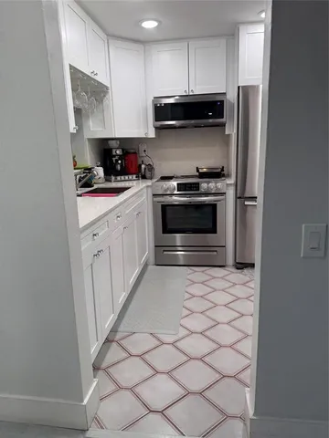 a kitchen with stainless steel appliances a stove a microwave and a refrigerator