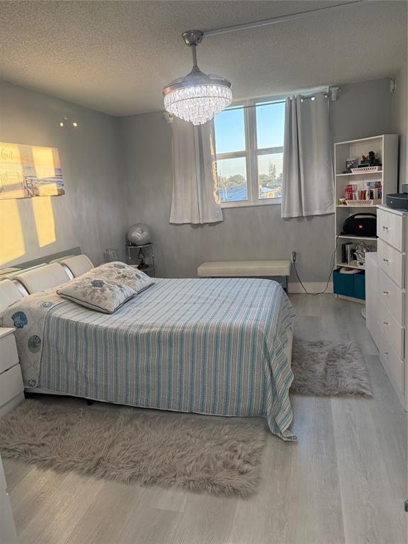 9360 Lime Bay Boulevard, Unit 202 Tamarac, FL 33321 - Photo 9 of 15 a bedroom with a bed and a chandelier