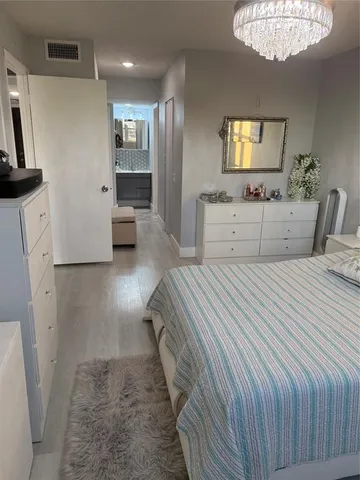 a bedroom with a large bed and a chandelier