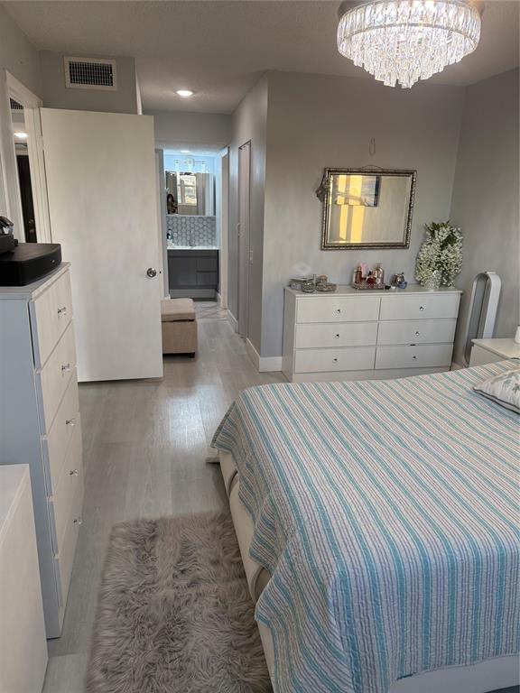 9360 Lime Bay Boulevard, Unit 202 Tamarac, FL 33321 - Photo 10 of 15 a bedroom with a large bed and a chandelier