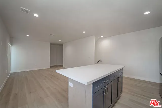 a kitchen with a sink cabinets and wooden floor