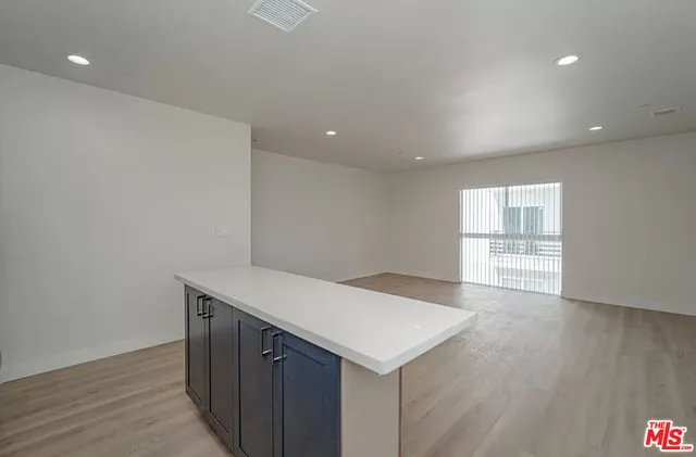 a kitchen with a wooden floor and white cabinets