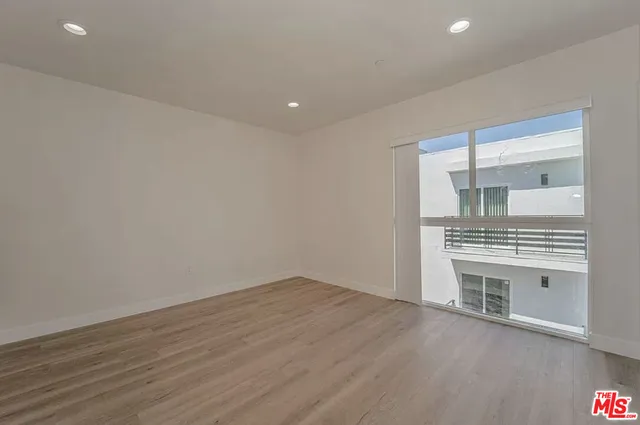 wooden floor in an empty room with a kitchen