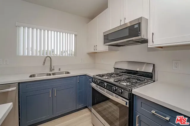 a kitchen with stainless steel appliances a sink a stove and microwave