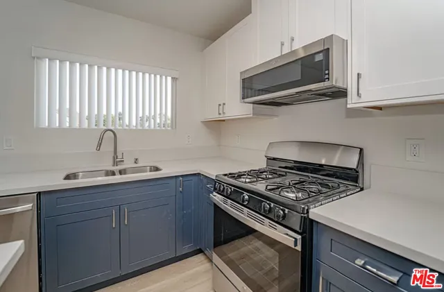 a kitchen with cabinets stainless steel appliances and a sink