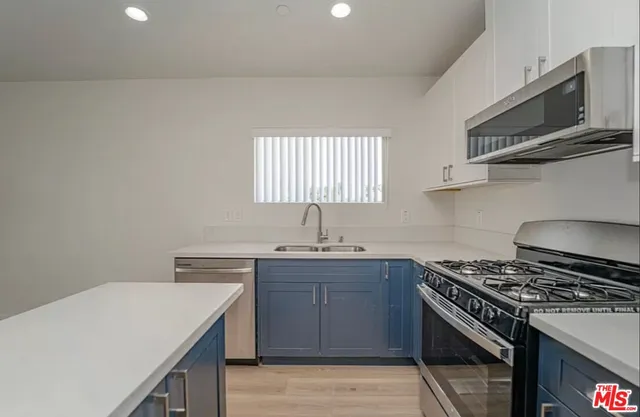 a kitchen with stainless steel appliances a sink dishwasher stove and oven with cabinets