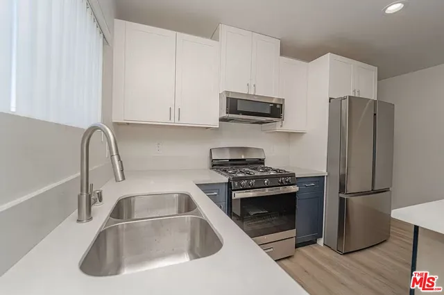 a kitchen with stainless steel appliances a refrigerator sink and microwave