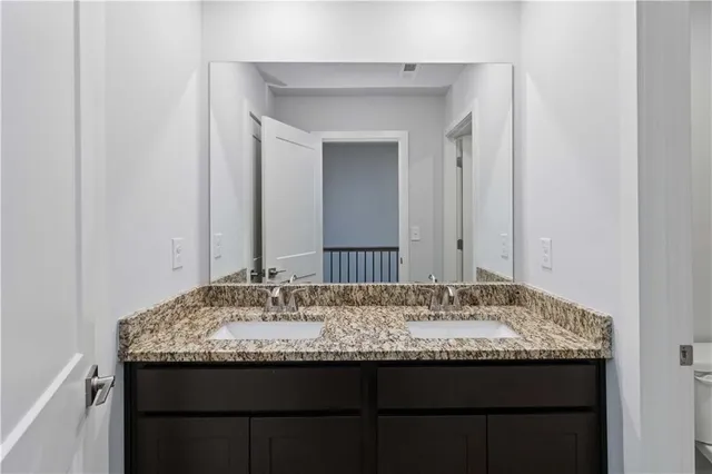 a bathroom with a granite countertop sink and a mirror