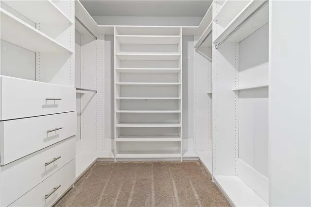 a view of walk in closet with empty racks