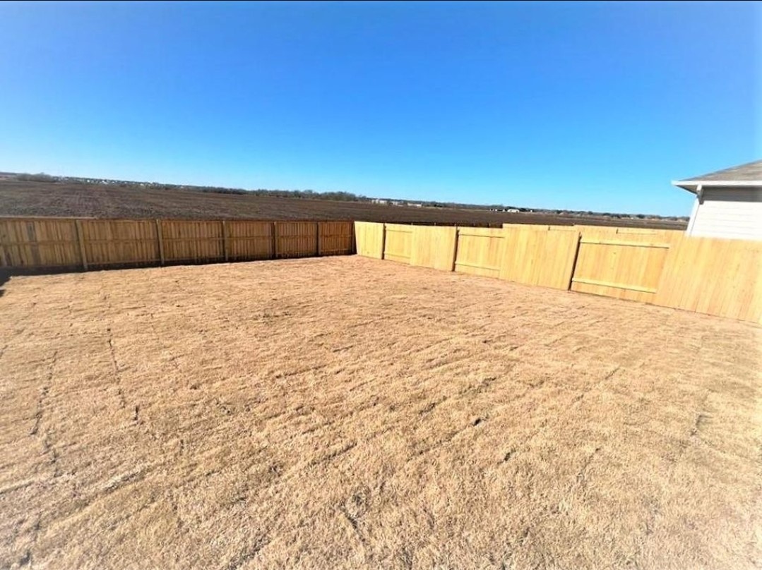 2771 Winding Creek Road Kyle, TX 78640 - Photo 19 of 24 A spacious backyard awaits, fully fenced for privacy, ready for personal landscaping touches.