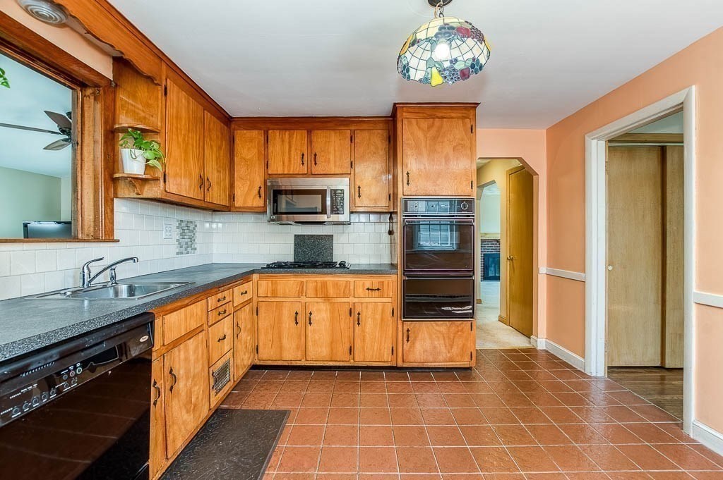 15 Locust Street Dedham, MA 02026 - Photo 13 of 38 a kitchen with stainless steel appliances a stove a sink and a refrigerator
