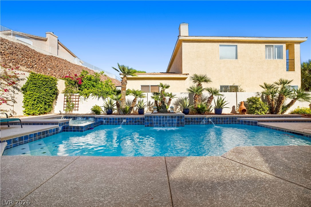 1135 Calico Ridge Drive Henderson, NV 89011 - Photo 49 of 86 An inviting backyard oasis offers a sparkling pool with cascading water features and lush landscaping.