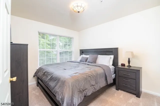 a large bed sitting in a bedroom next to a window