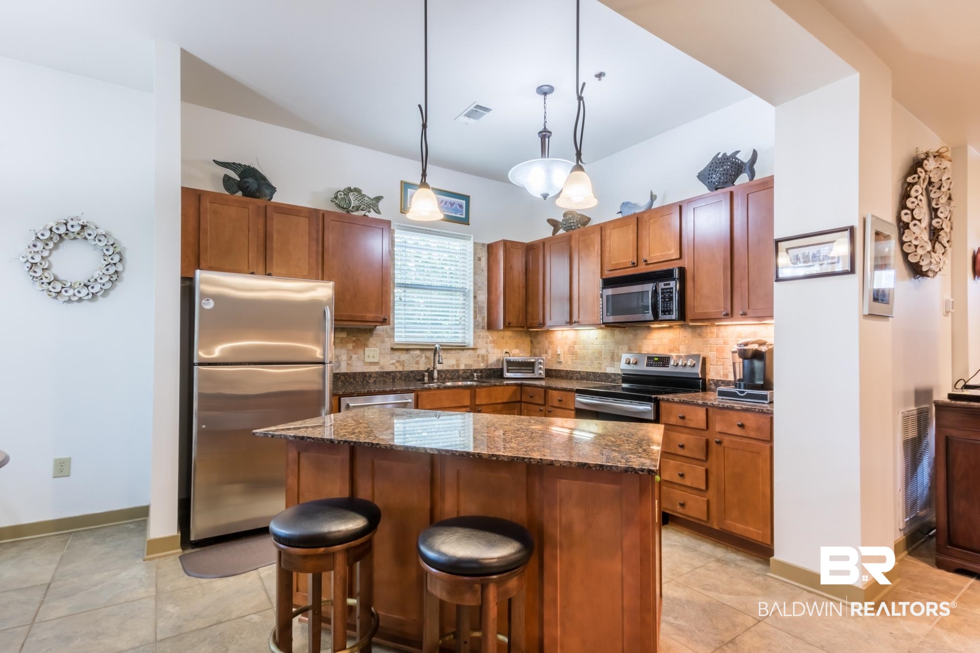 1430 Regency Road, Unit G103 Gulf Shores, AL 36542 - Photo 3 of 29 Kitchen with decorative light fixtures, stainless steel appliances, tasteful backsplash, a center island, and light tile floors
