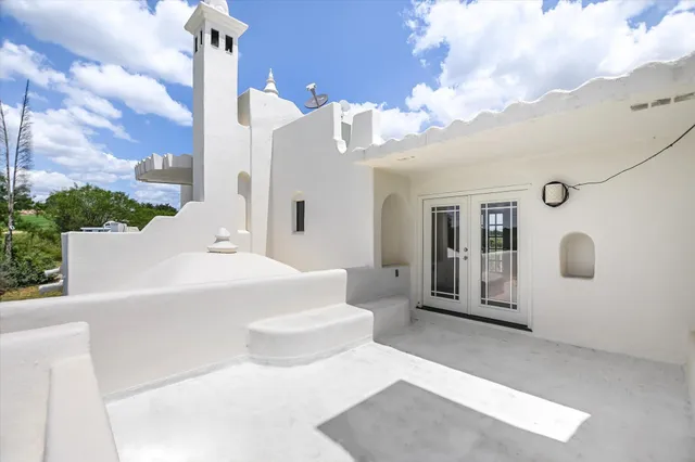a view of a white house with swimming pool and sitting space
