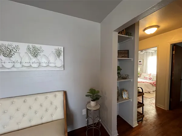 a view of a hallway with wooden floor and a dining table