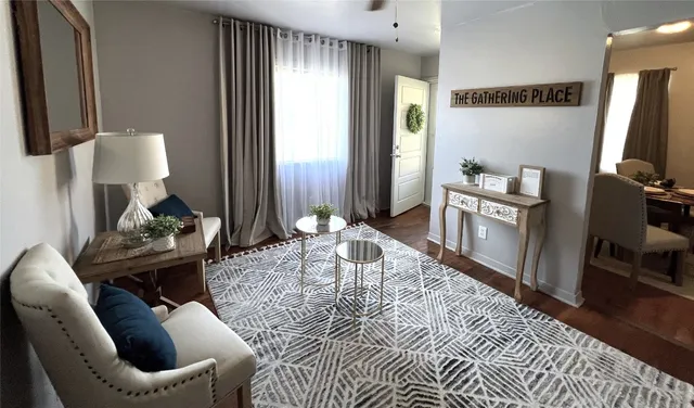 a living room with furniture a rug and a flat screen tv