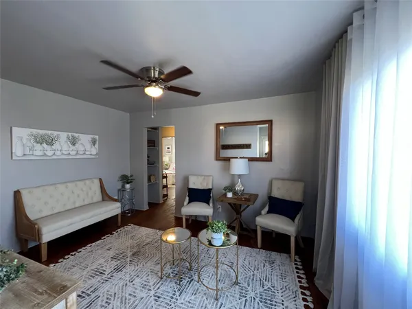 a living room with furniture a rug and a window