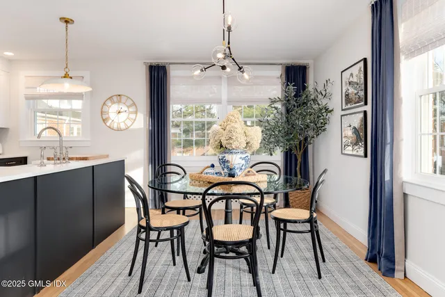 a dining room with furniture a chandelier and wooden floor