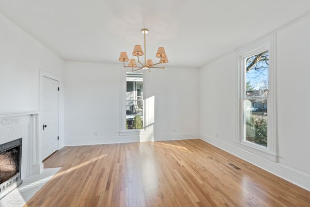a view of a livingroom with wooden floor and a fireplace