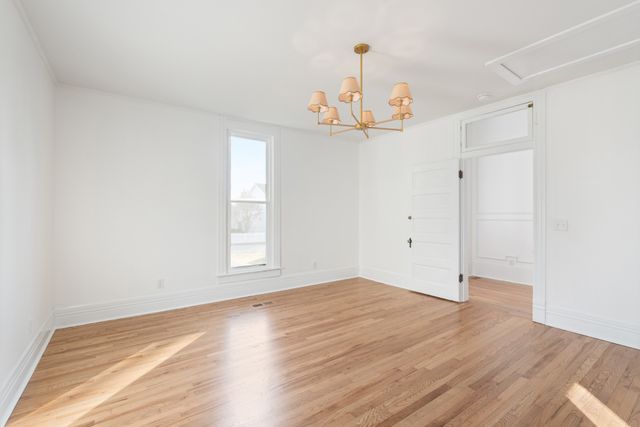 a view of empty room with wooden floor and fireplace