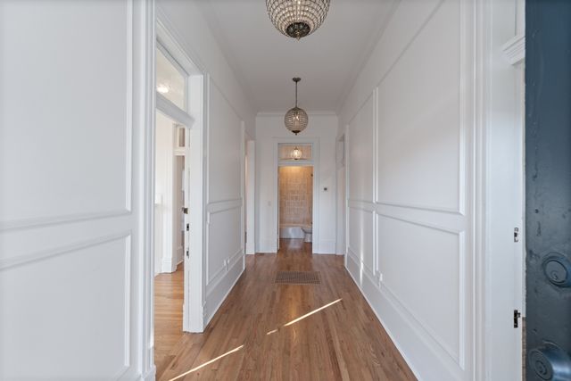 a view of a hallway with wooden floor