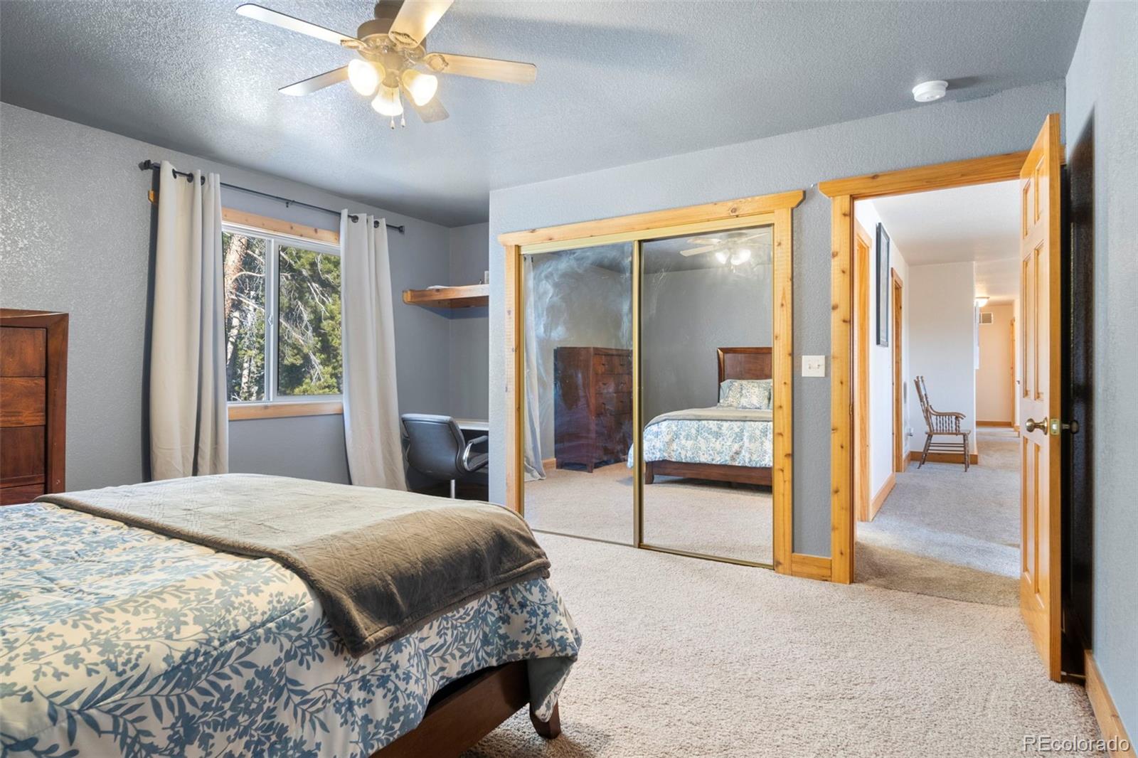 412 Evergreen Road Black Hawk, CO 80422 - Photo 38 of 48 a bedroom with a large bed and a chandelier