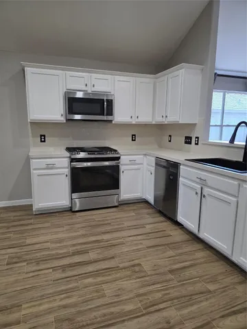a kitchen with stainless steel appliances granite countertop a stove a sink and a microwave