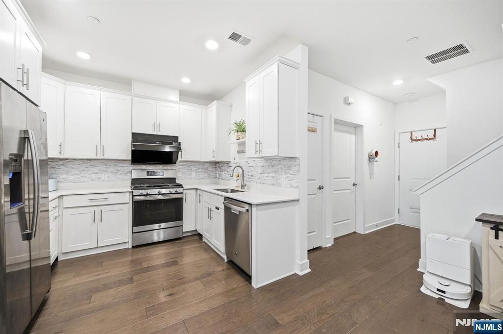 385 Main Street Little Falls, NJ 07424 - Photo 7 of 42 a kitchen with granite countertop white cabinets and appliances
