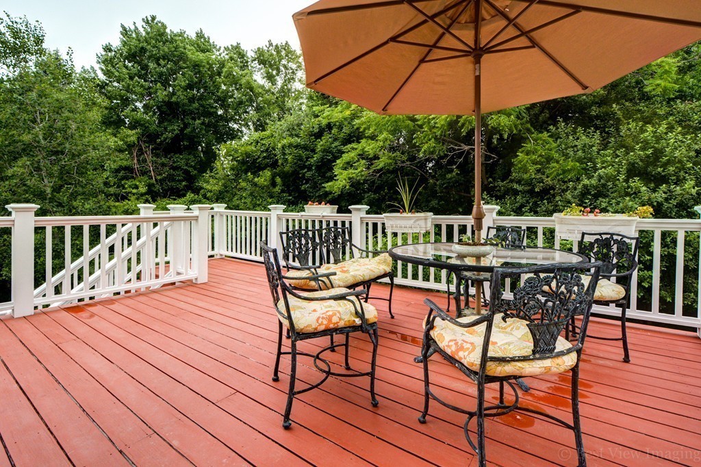 15 Idylwilde Road Lexington, MA 02421 - Photo 5 of 26 a patio with wooden floor a yard a table and chairs
