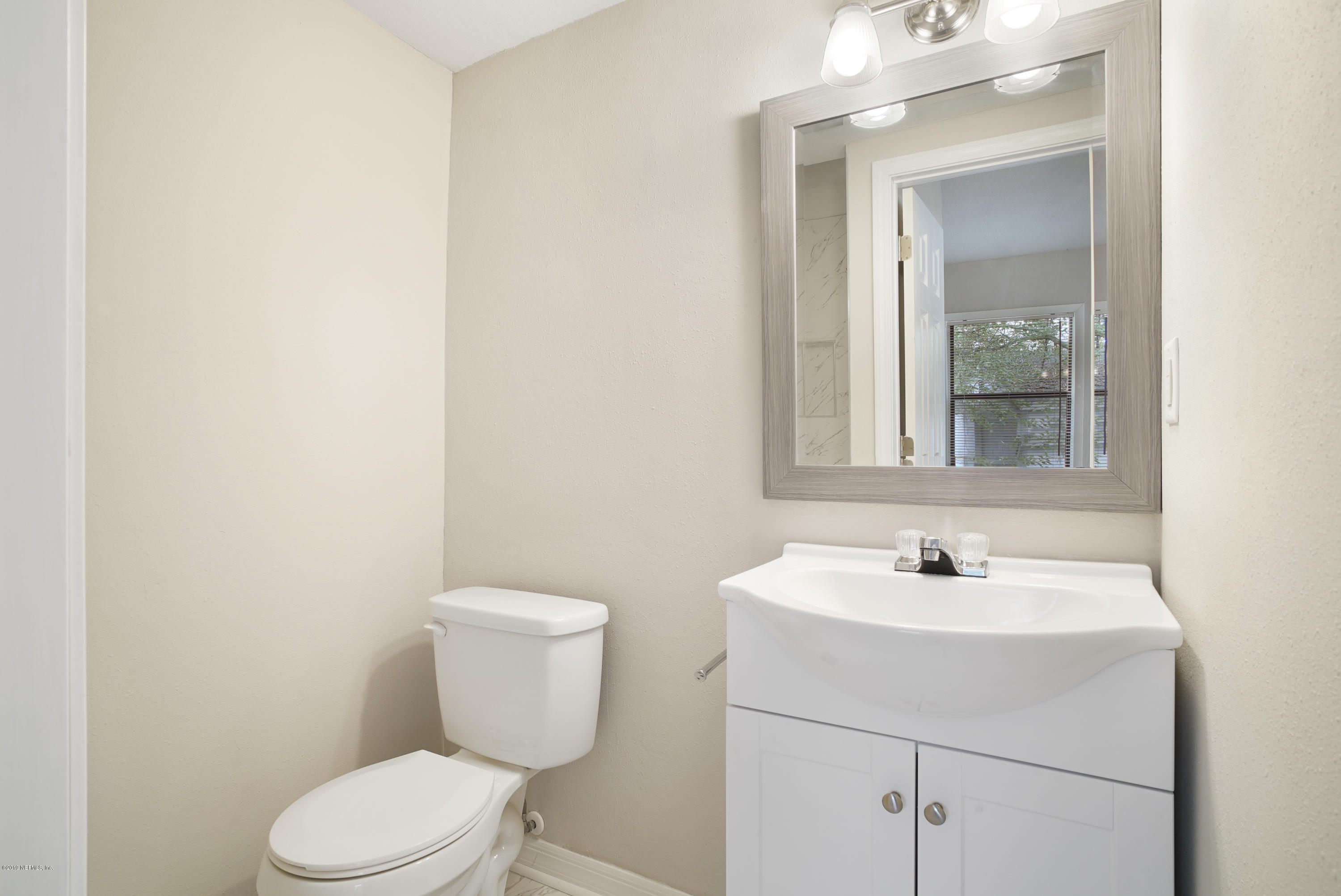 4714 Dundee Road Jacksonville, FL 32210 - Photo 12 of 22 a bathroom with a toilet sink and mirror