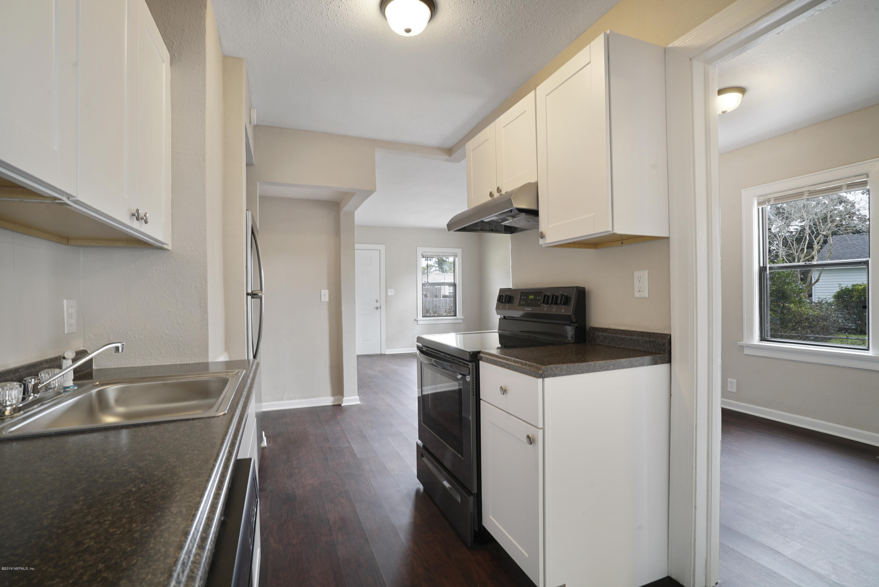 4714 Dundee Road Jacksonville, FL 32210 - Photo 6 of 22 a kitchen with granite countertop a sink stove and cabinets
