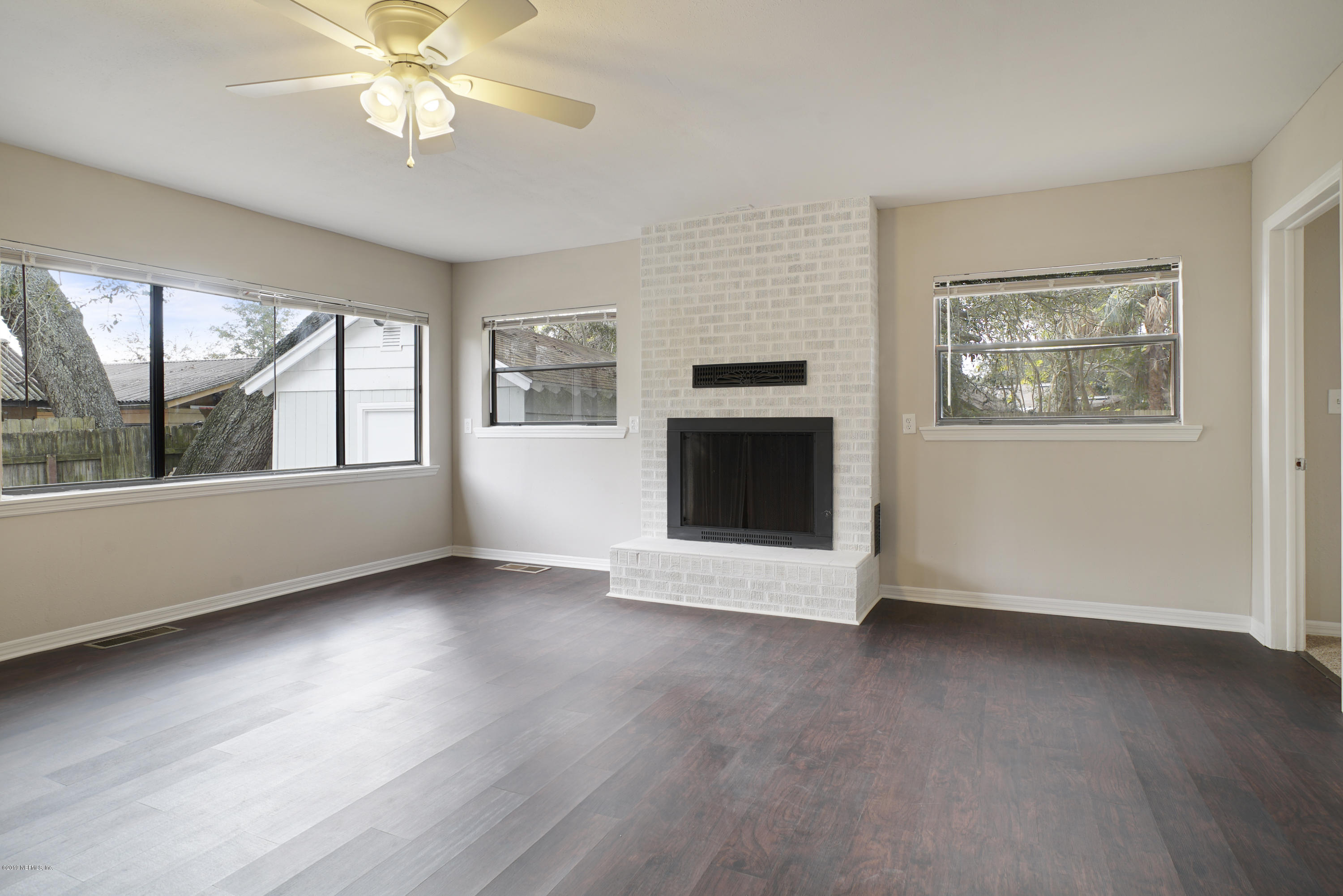 4714 Dundee Road Jacksonville, FL 32210 - Photo 8 of 22 a view of an empty room with a window and wooden floor