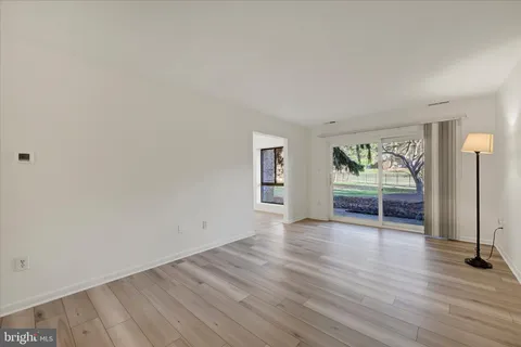 an empty room with wooden floor and a window